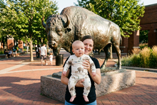 Load image into Gallery viewer, Baby in the bison romper near a large cast-metal buffalo sculpture