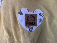 Load image into Gallery viewer, Bee and floral hoodie with curved printed pocket edging and blue pocket interiors.
